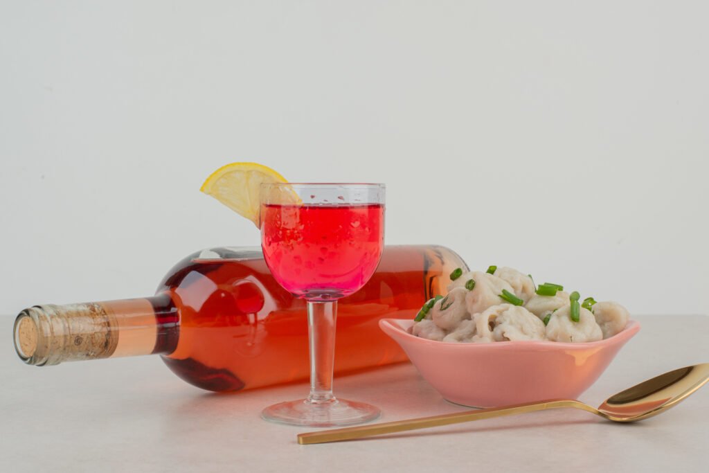 Bottle with glass of lemonade and plate of dumplings
