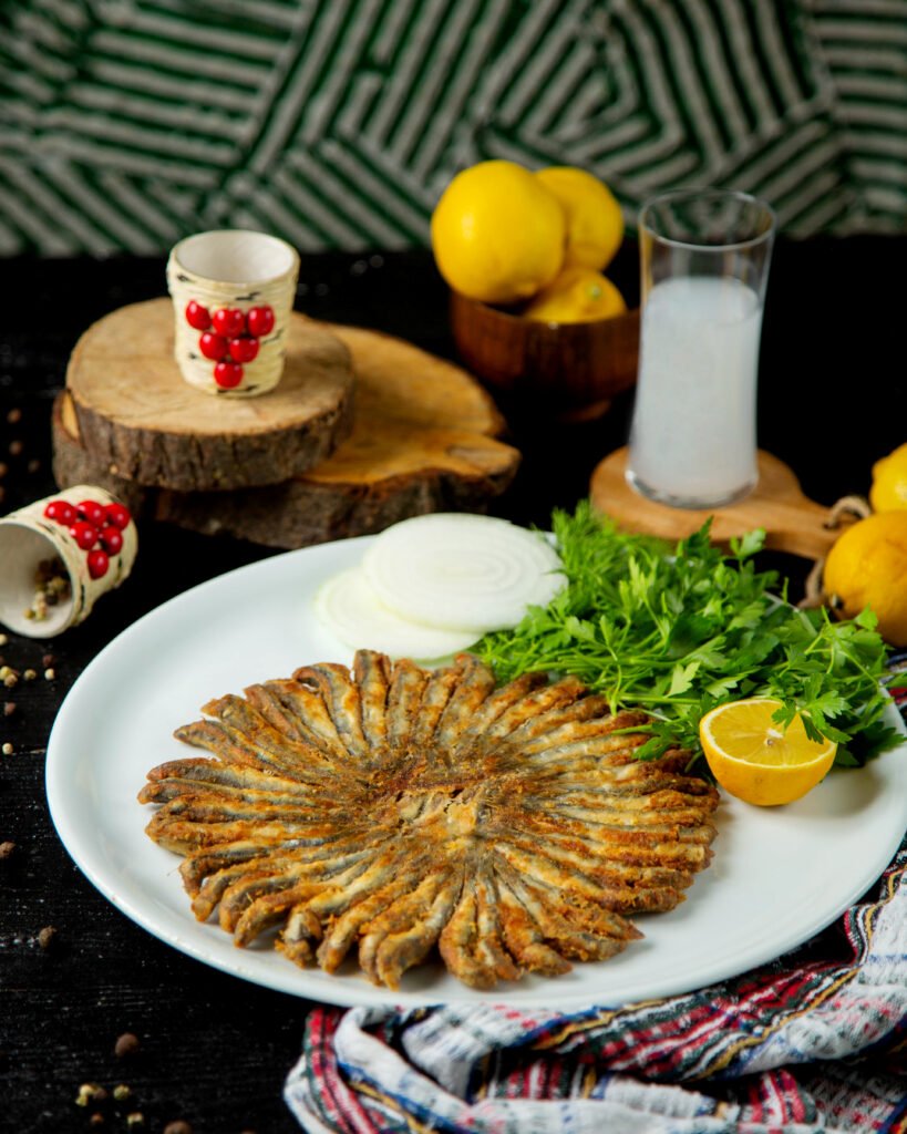 fried sprats in round shape served with parsley and lemon