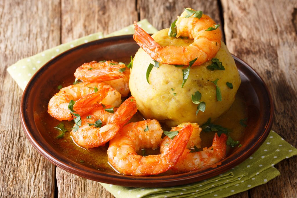 latino-american-main-course-mofongo-with-shrimps-and-broth-close-up-on-a-plate-horizontal-51551929080