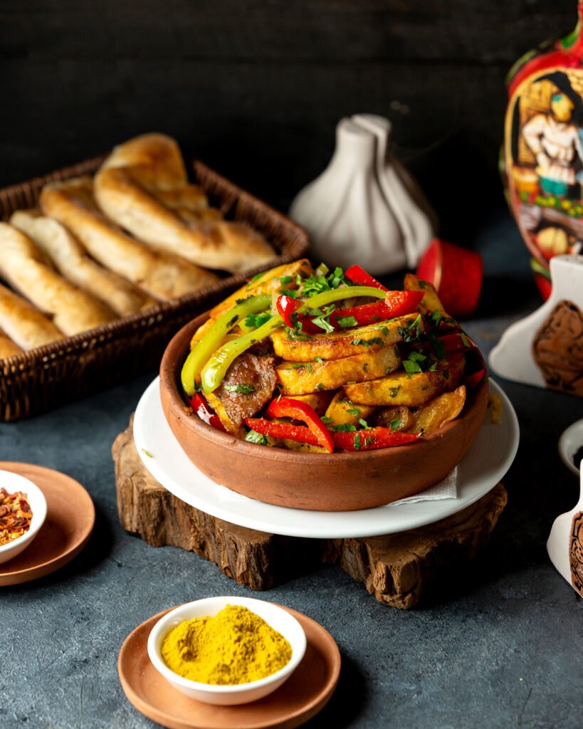 side-view-baked-potatoes-with-lamb-meat-vegetables-clay-bowl-black-table