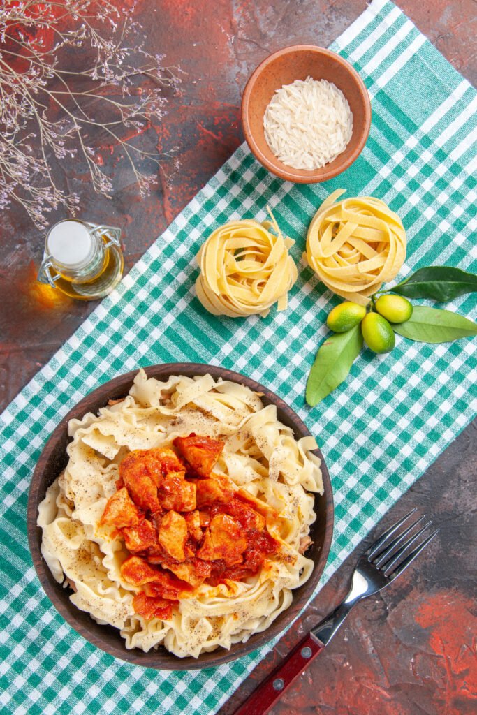 top-view-tasty-cooked-dough-with-chicken-sauce-dark-surface-pasta-food