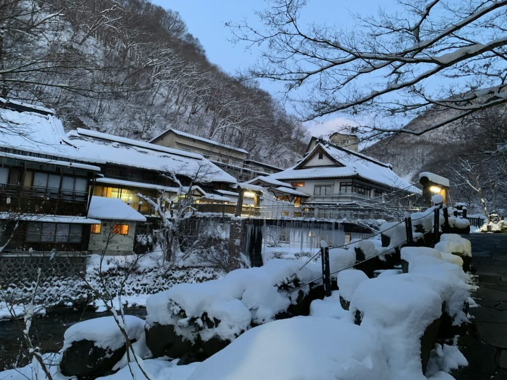 Charming snow-covered village in Takayama, Japan, captured at twilight, showcasing serene winter beauty.
