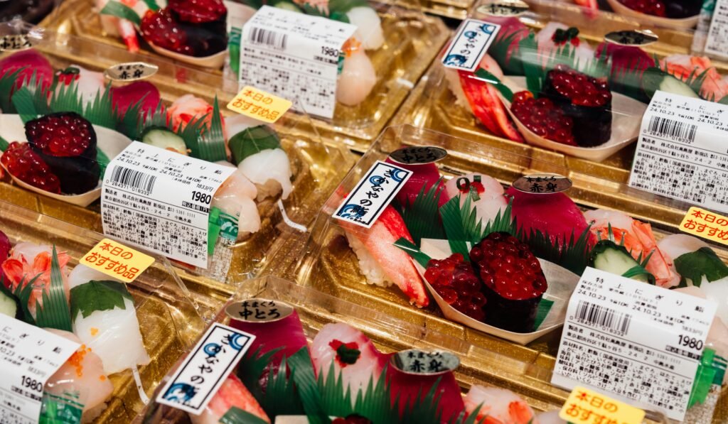 pexels-photo-29518226-29518226 Freshly prepared assorted sushi in traditional Japanese packaging displayed in a market.