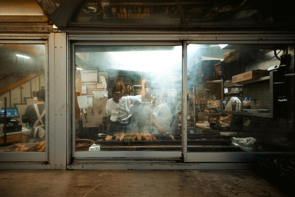 pexels-photo-3423881-3423881 Chefs preparing food in a smokey kitchen at a Tokyo street food restaurant.