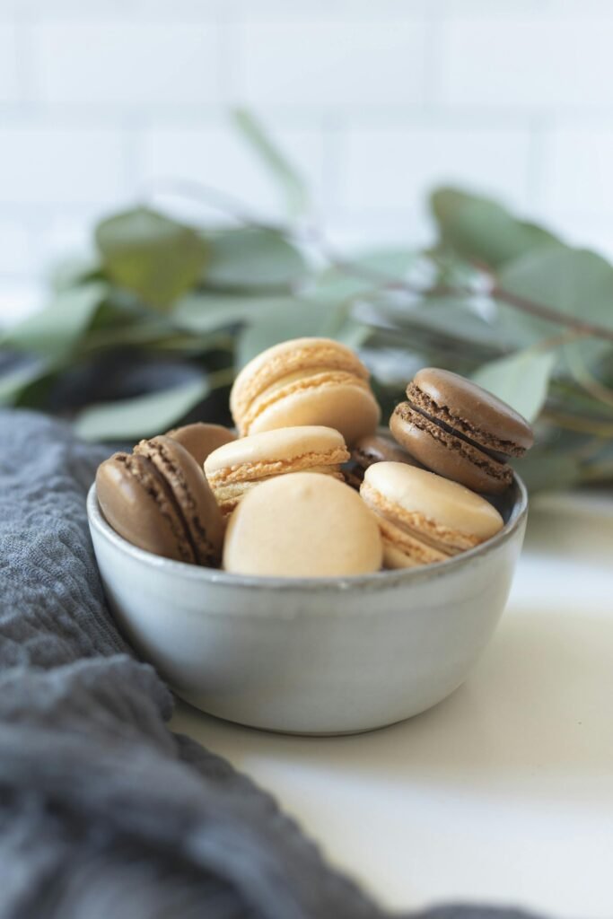 Close-up of assorted French macarons in a rustic bowl, perfect for food photography.